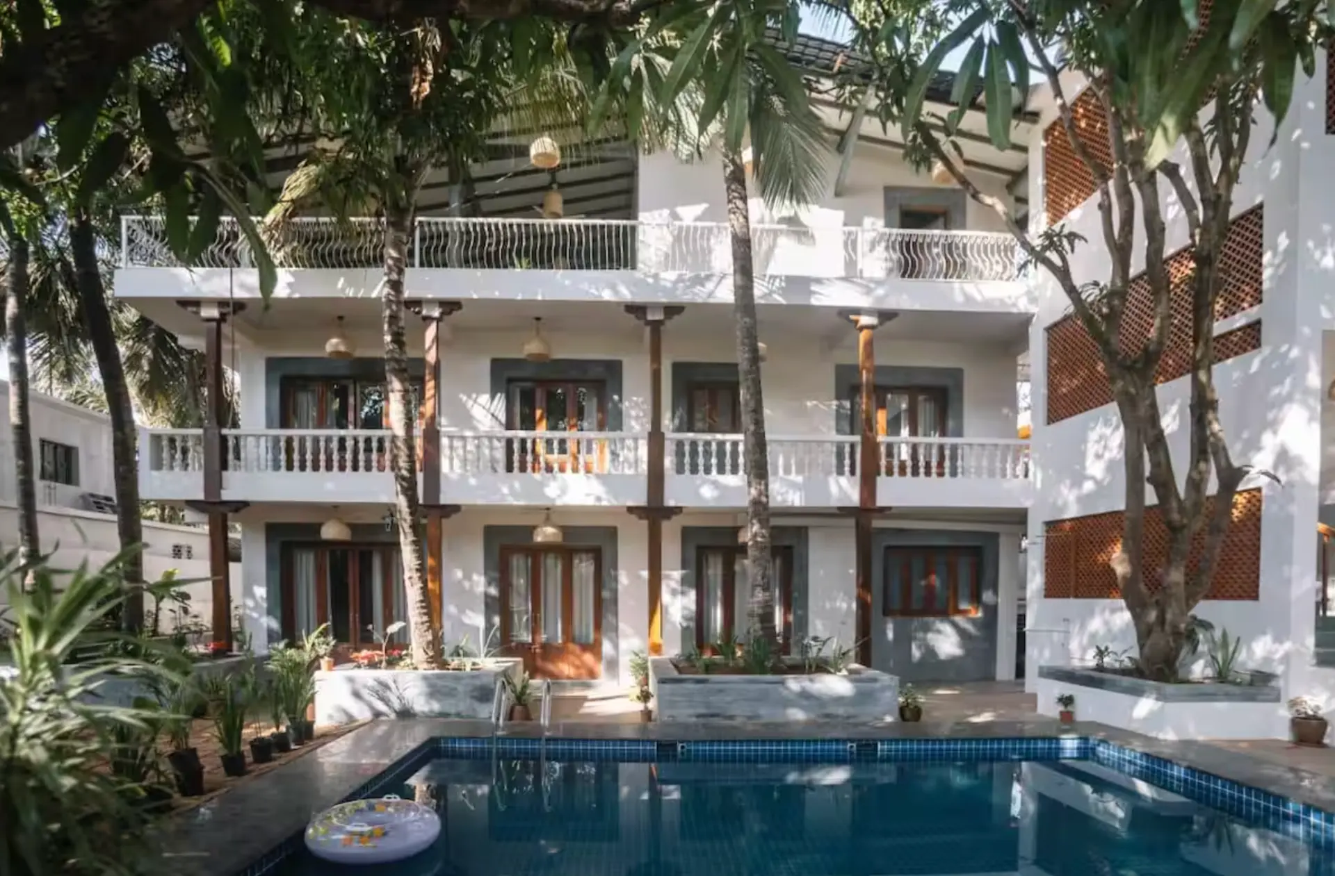 The villa exterior with pool and palm trees